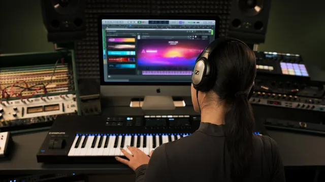 Musician with headphones producing in Kontakt in a studio